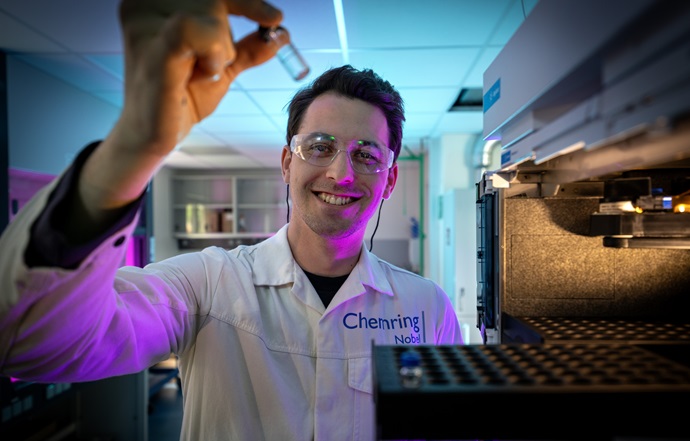 White coat worker holding chemistry vile